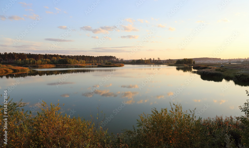 Pond in countryside in autumn at sunset