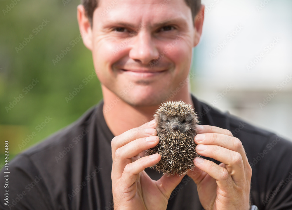 Young man with hedgehog baby