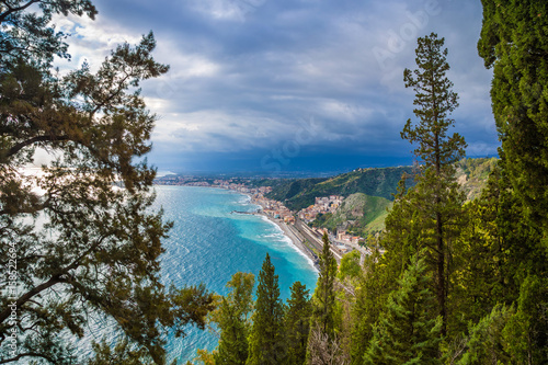 Naxxos, Sicily - Beautiful aerial landscape view of Giardini Naxxos town and beach with turquoise sea water and pine trees in front © zgphotography