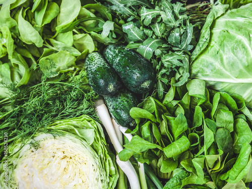 Background of a lot of fresh green different vegetables and herbs, top view, close-up. The concept of healthy, proper nutrition, diet, detox, cleansing photo