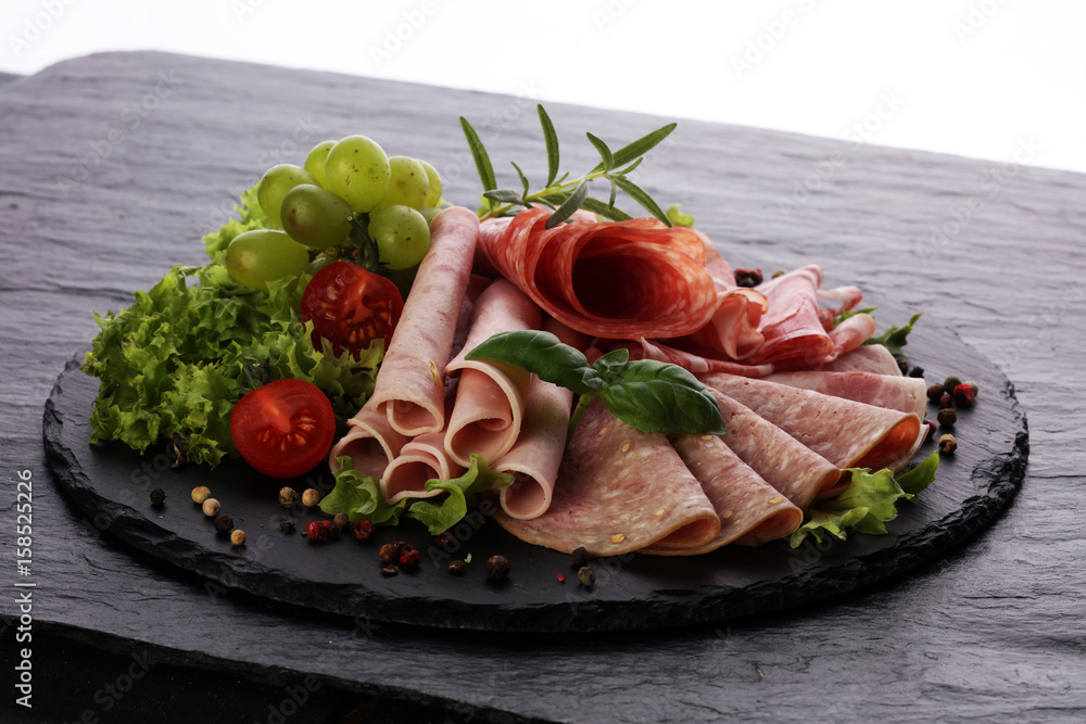 Food tray with delicious salami, pieces of sliced ham, sausage, tomatoes, salad and vegetable - Meat platter with selection Food tray with delicious salami, pieces of sliced ham, sausage, tomatoes, salad and vegetable - Meat platter with selection
