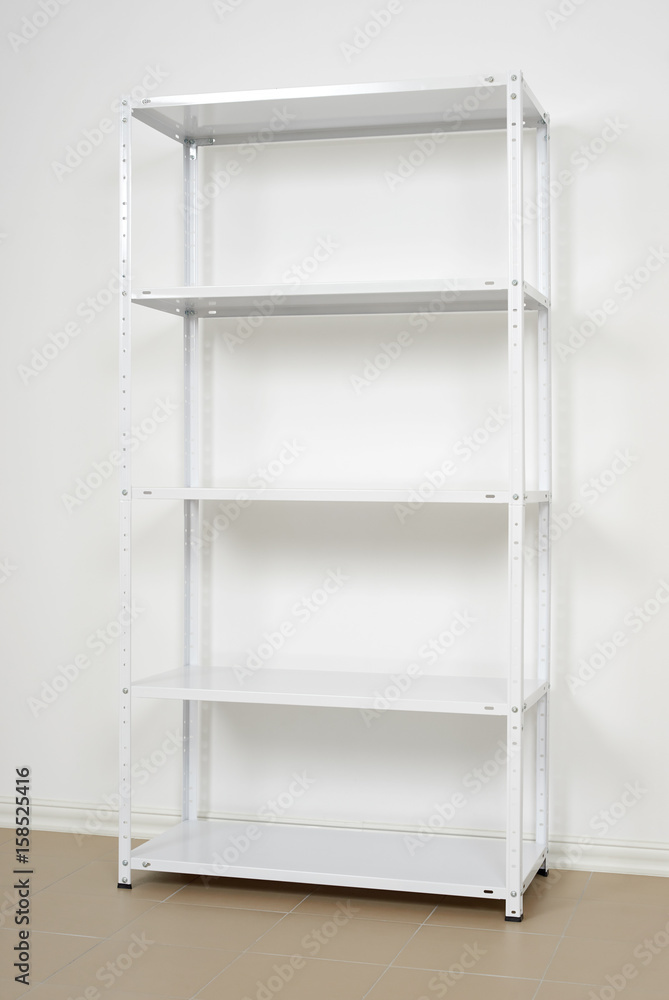 white metal rack near the wall, empty shelves white metal rack near the wall, empty shelves