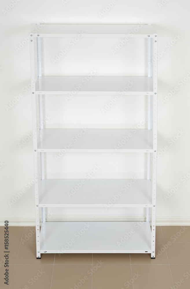 white metal rack near the wall, empty shelves white metal rack near the wall, empty shelves