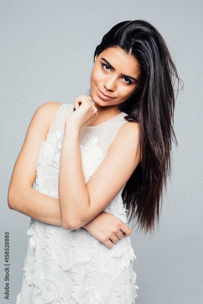 Beautiful woman standing in a dress over gray background Beautiful woman standing in a dress over gray background