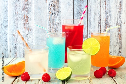 Group of cool colorful summer drinks against a rustic wood background
