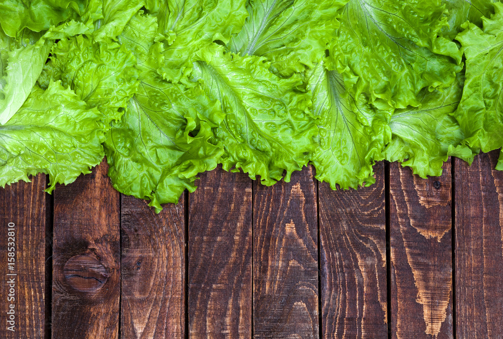 Fototapeta premium Lettuce on wooden table. Top view, copy space