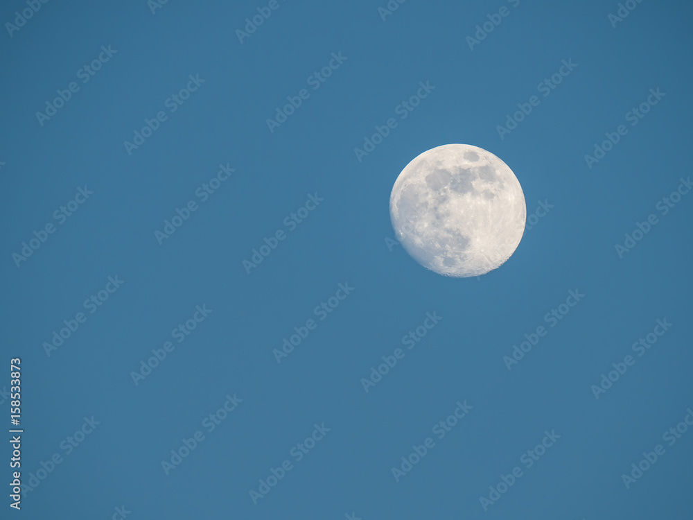 near full moon and cloudless blue sky