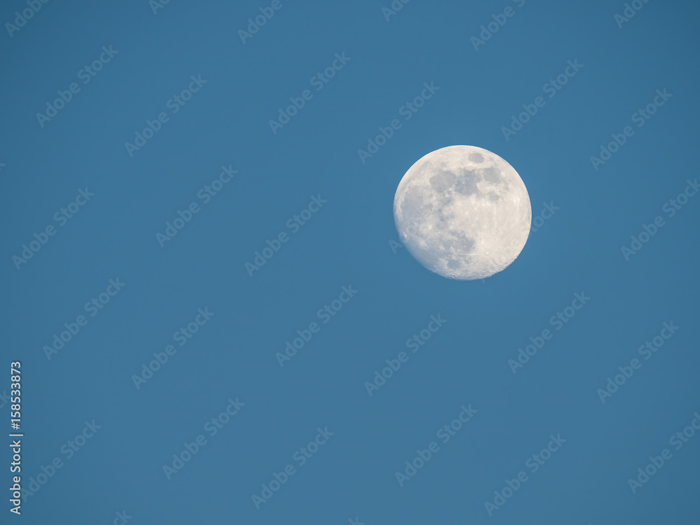 near full moon and cloudless blue sky near full moon and cloudless blue sky