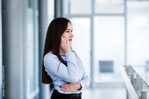 Serious business woman talkin on phone in modern interior Free Download Serious business woman talkin on phone in modern interior - GFXLoad