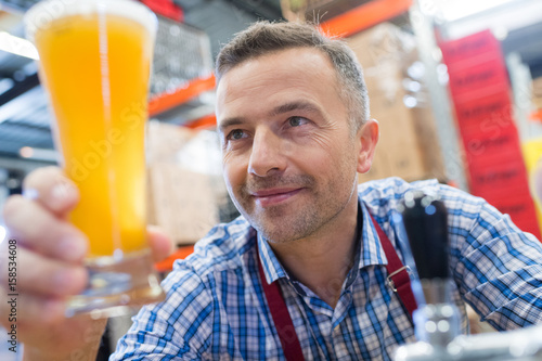 Worker admiring glass of lager