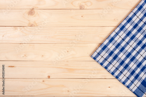 blue checkered tablecloth on a light wooden table with copy space for your text. Top view