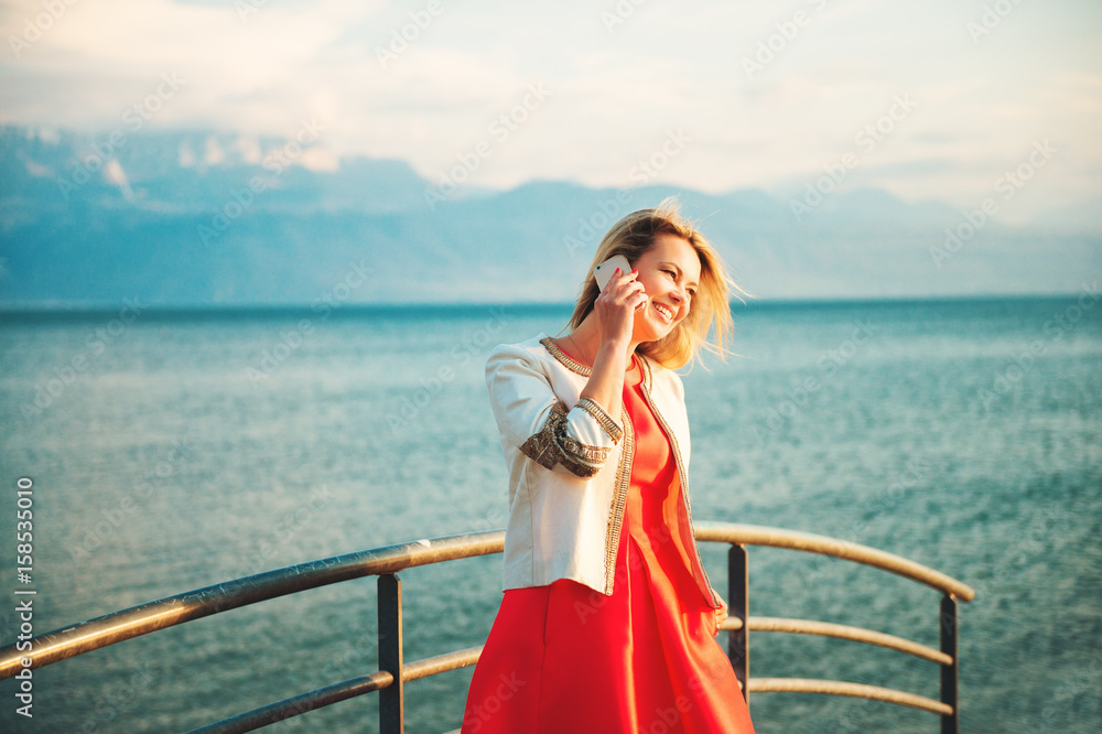Outdoor portrait of laughing beautiful blond woman talking on the phone Outdoor portrait of laughing beautiful blond woman talking on the phone