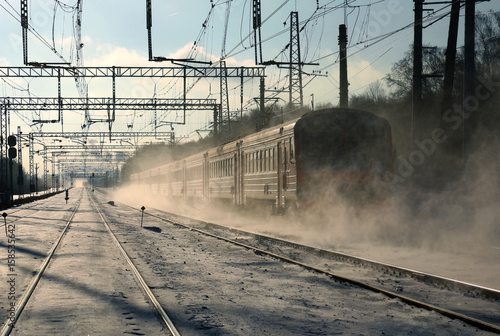 A passenger train goes by rail in winter