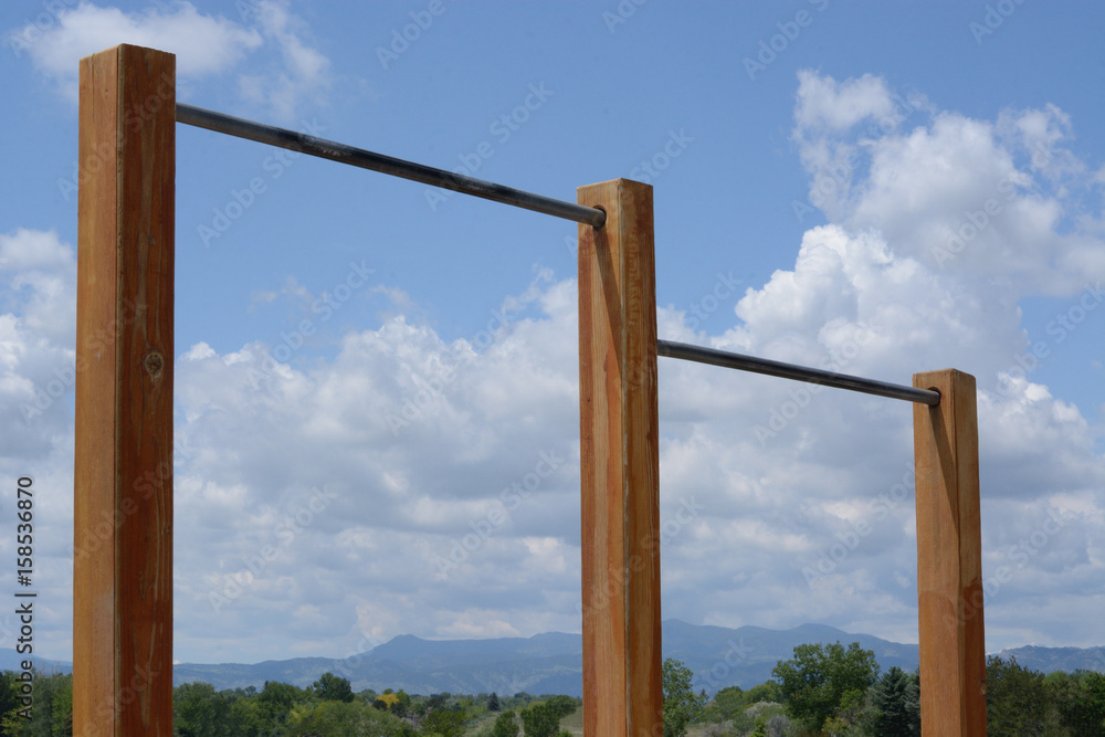 Outdoor circuit chin up bars with Rocky Mountains and sky in background
