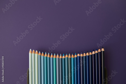 Colour pencils isolated on purple background close up
