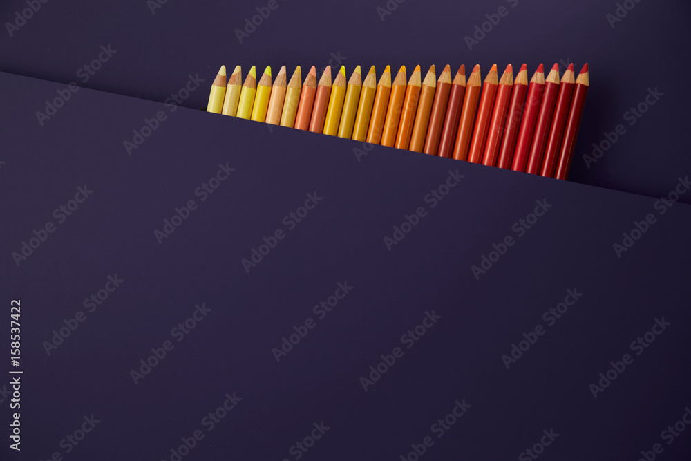 Colour pencils isolated on purple background close up Colour pencils isolated on purple background close up