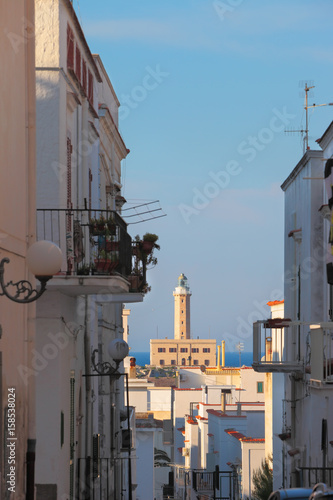 Far view of Vieste lighthouse from the city at sunset, Gargano, Apulia, Italy