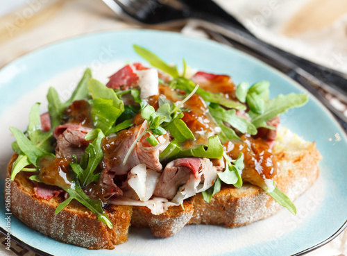 Bruschetta with beef, arugula and sweet and sour sauce.