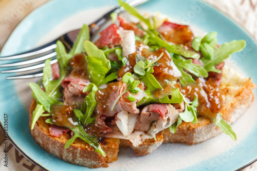 Bruschetta with beef, arugula and sweet and sour sauce.