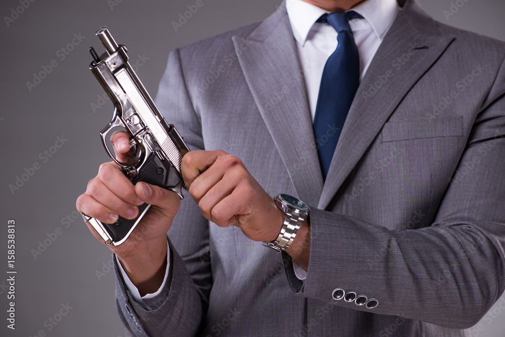 Businessman pulling the gun out of pocket Businessman pulling the gun out of pocket