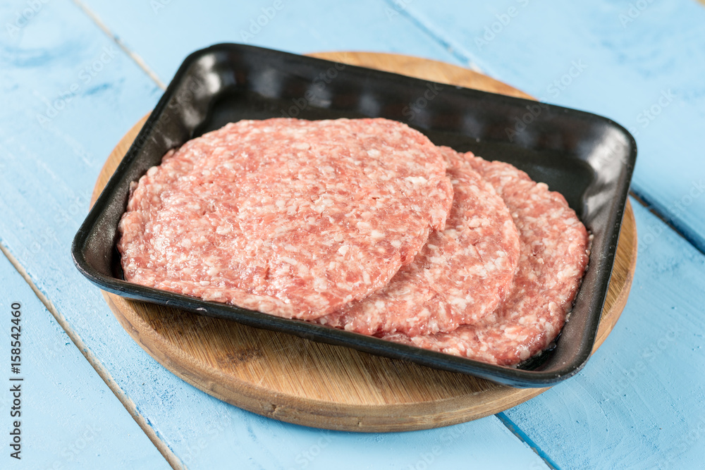 Raw minced meat burgers in the market package with price tag Raw minced meat burgers in the market package with price tag