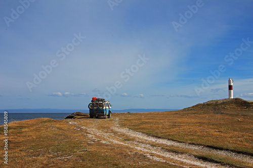 Van camping at the lighthouse and the bay of Porvernir, Tierra Del Fuego, Patagonia, Chile photo