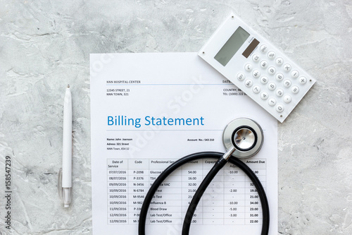 medical treatmant billing statement with stethoscope and calculator on stone background top view photo