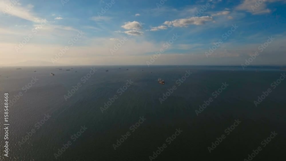 Aerial view Cargo ships in the Bay of Manila. Large container ship in the sea. Flying over the water surface of the sea with ships, blue sky and clouds. 4K video. Aerial footage. Philippines, Manila. Aerial view Cargo ships in the Bay of Manila. Large container ship in the sea. Flying over the water surface of the sea with ships, blue sky and clouds. 4K video. Aerial footage. Philippines, Manila.
