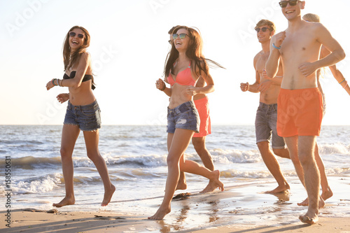 Happy friends running on beach