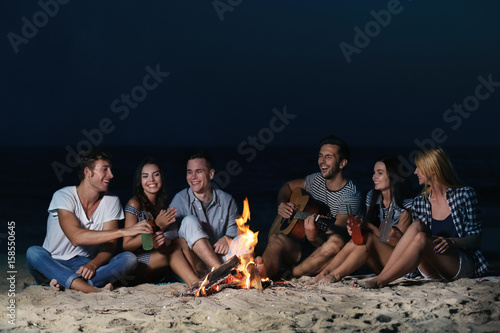 Happy friends near fireplac...