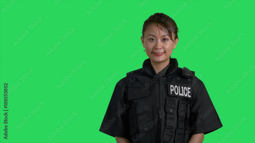 Asian police officer in flak jacket smiles at camera Asian police officer in flak jacket smiles at camera