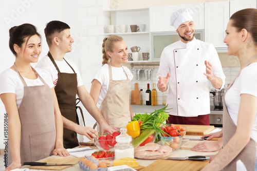 Male chef and group of peop...