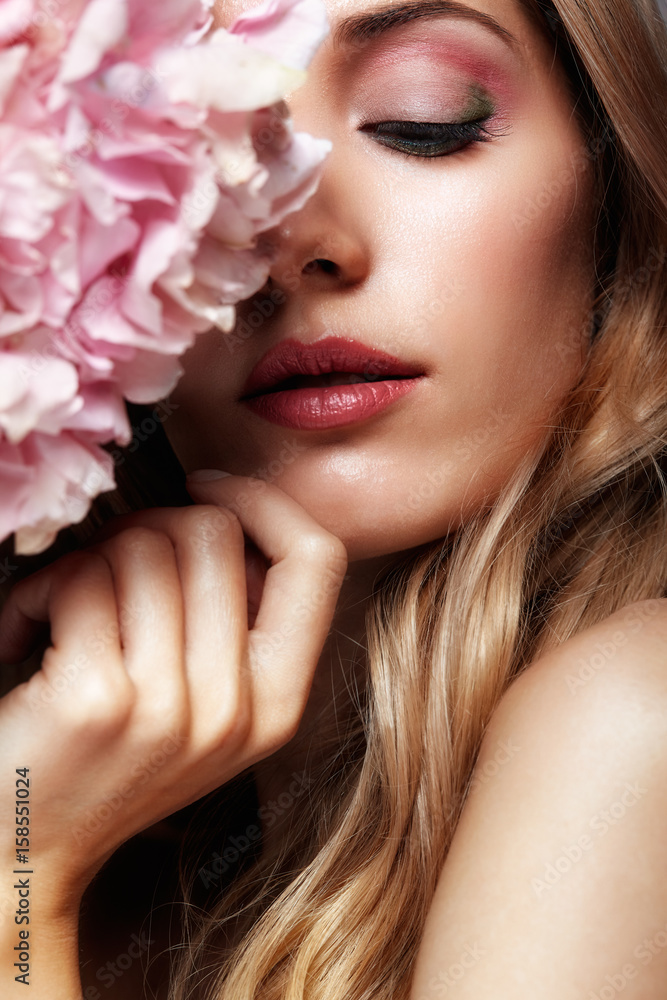 Closeup portrait of young beauty female face with blond hair and hydrangea bouquet flowers