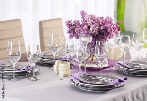 Beautiful table setting with silver cutlery and lilac bouquet
