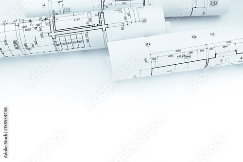 rolls of paper with graphical plans and architectural projects on white background