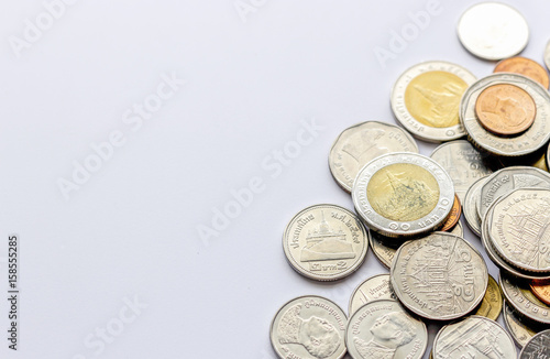 coins tower (Thai money) on white table with over light and soft-focus in the background
