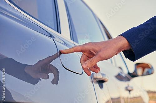 A man wants to open a gasoline tank.