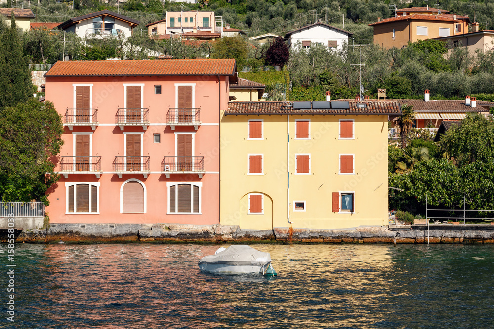 colorful houses on the shore. Lake Garda is the largest lake in Italy. It is located in Northern Italy, about half-way between Brescia and Verona, and between Venice and Milan.