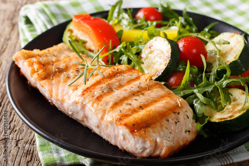 Photography Tasty fillet of grilled salmon and vegetable salad with arugula close-up
