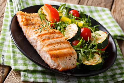 Healthy food: grilled salmon fillets with vegetable salad and arugula closeup. horizontal
