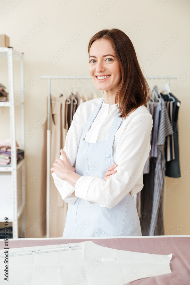 Young smiling woman seamstress looking camera Young smiling woman seamstress looking camera