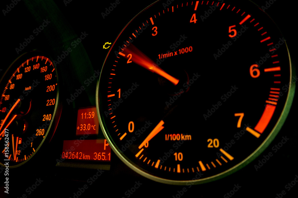 Check engine light with motion RPM meter. Car dashboard in closeup 