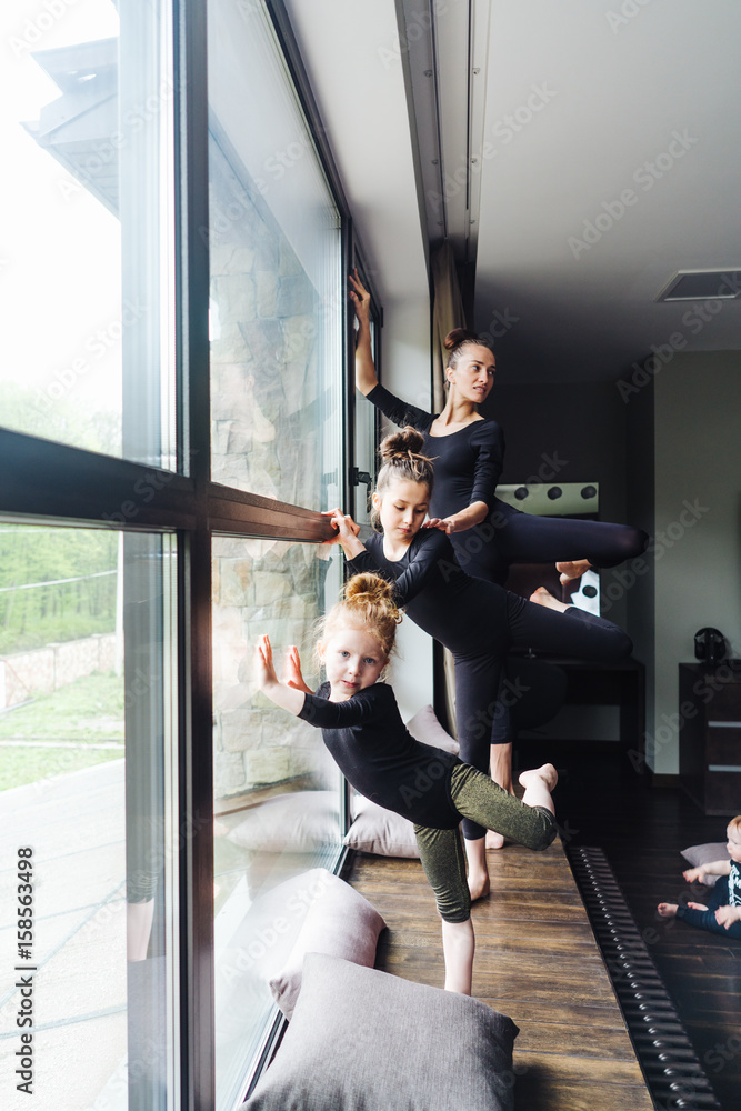 Mom and two daughters practice ballet Mom and two daughters practice ballet