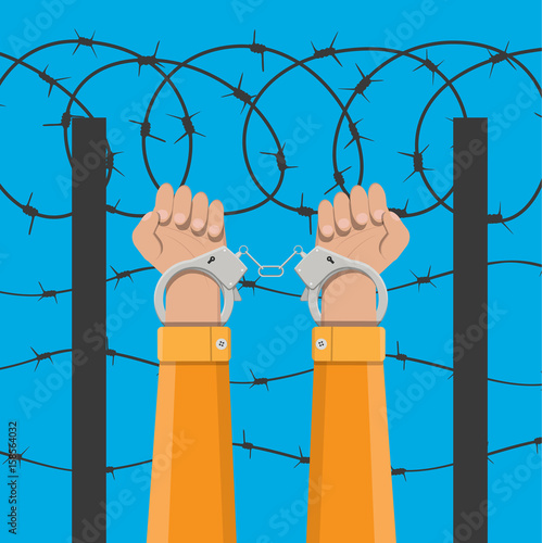 Handcuffs on hands and barbed wire