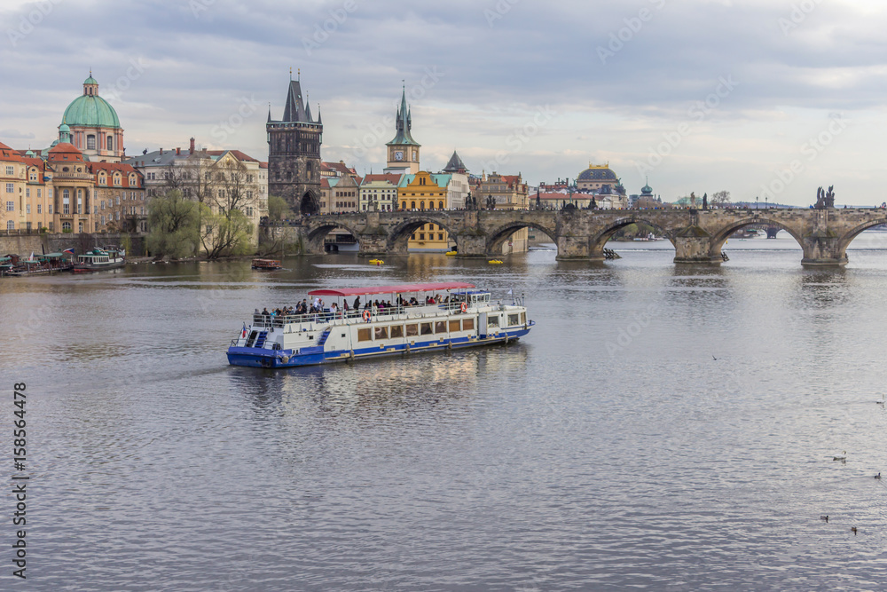 Obraz premium View of the Charles Bridge and pleasure craft from the side of the Manes Bridge. The River Vltava. Area of the Old Town. Prague, Czech Republic.