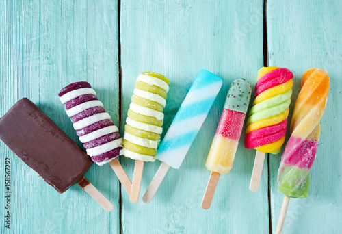 colorful popsicle ice cream on turquoise wooden background photo