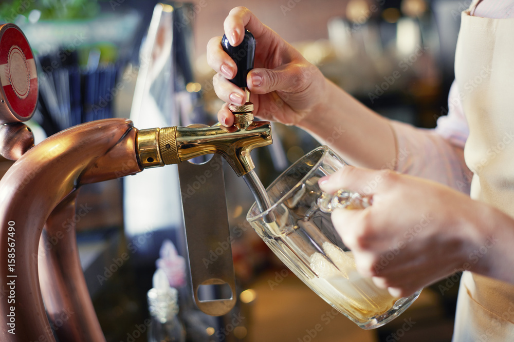 Close up of bartender pouring pint of beer