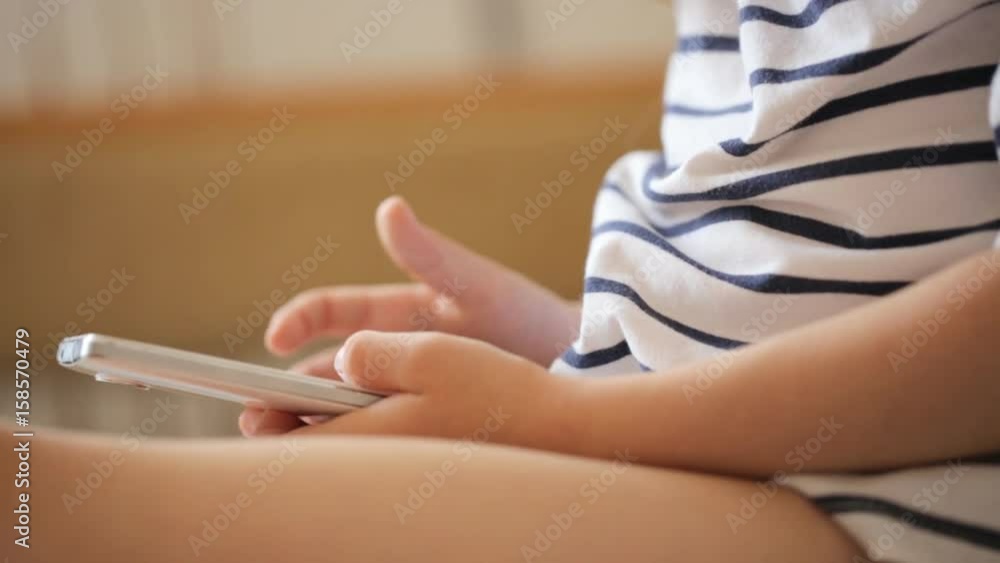 Little girl playing with the smartphone