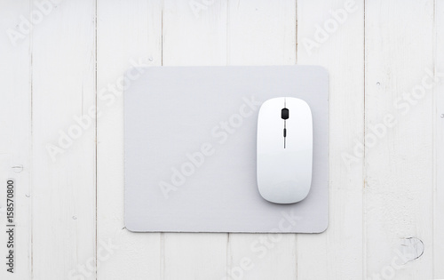 White wireless mouse on a mouse pad, top view photo