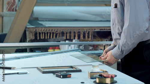 Schilderij op canvas Male senior worker measure width and height of glass in workshop